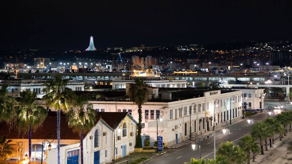 Abdoulaye Maïga à Alger pour une visite de travail A nighttime cityscape of Alger Centre, featuring the illuminated Maqam Echahid in the background.