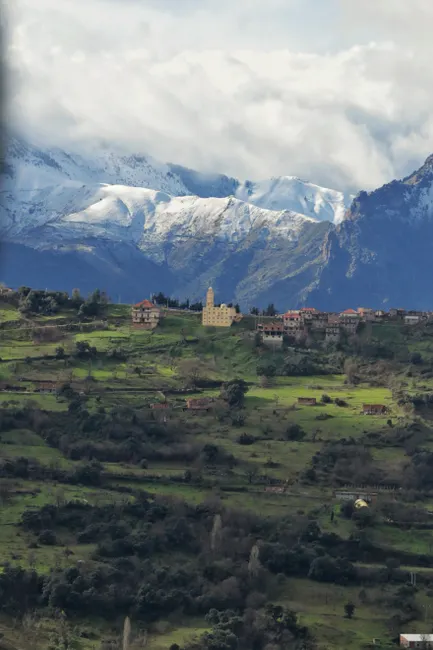 Breathtaking landscape of Tizi Ouzou, Algeria showcasing lush greenery and snow-capped mountains.