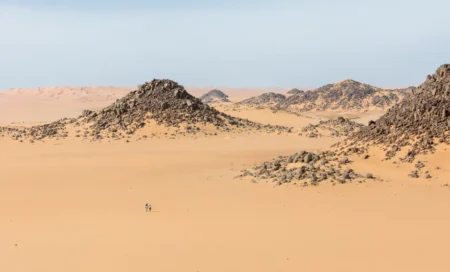Météo en Algérie : 49 °C au Sud et pluies localisées Expansive desert scene with rocky formations in Illizi, Algeria, showcasing the barren beauty of the Sahara.