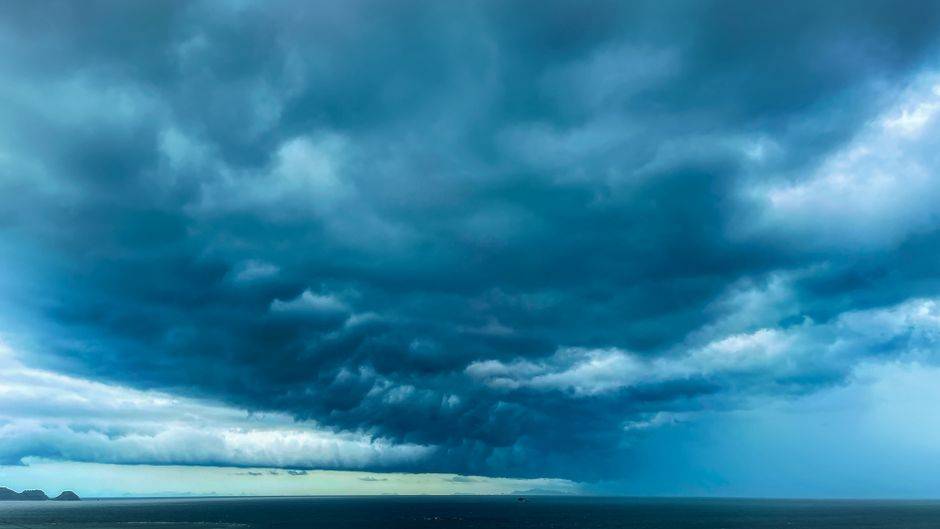 Orages en Algérie : plus de 50 mm possibles localement A dramatic formation of dark storm clouds hovering over a vast ocean expanse.