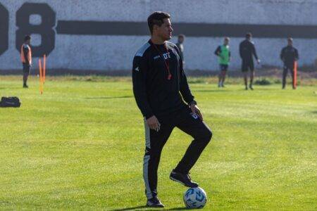 Fodil Charef attribue à Hamdani une personnalité de leader Adult soccer coach guiding players during outdoor training on a sunny day.
