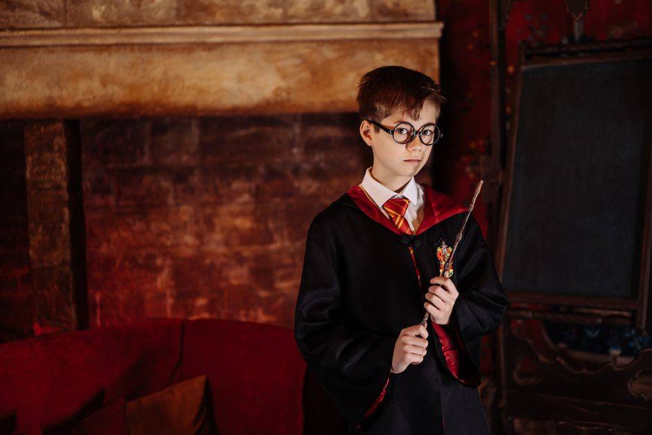 Yoda : quatre phrases cultes et le piège des fausses citations Boy dressed as a wizard with eyeglasses and robe holding a wand in front of a fireplace.