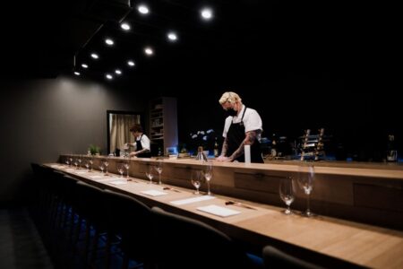 Sushi à San Francisco : du comptoir à l’omakase Chefs preparing sushi at an elegant omakase bar in a dimly lit Japanese restaurant.