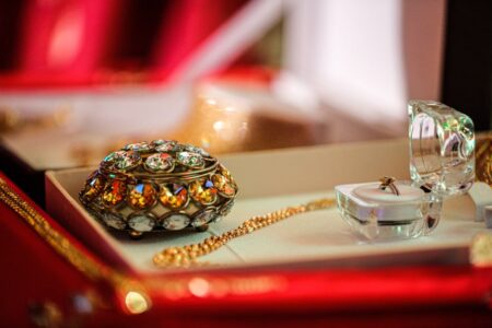 Des bijoux en or retrouvés dans les déchets grâce à un reçu Close-up of a luxurious jewelry box with exquisite gold and jeweled accessories in an elegant display.