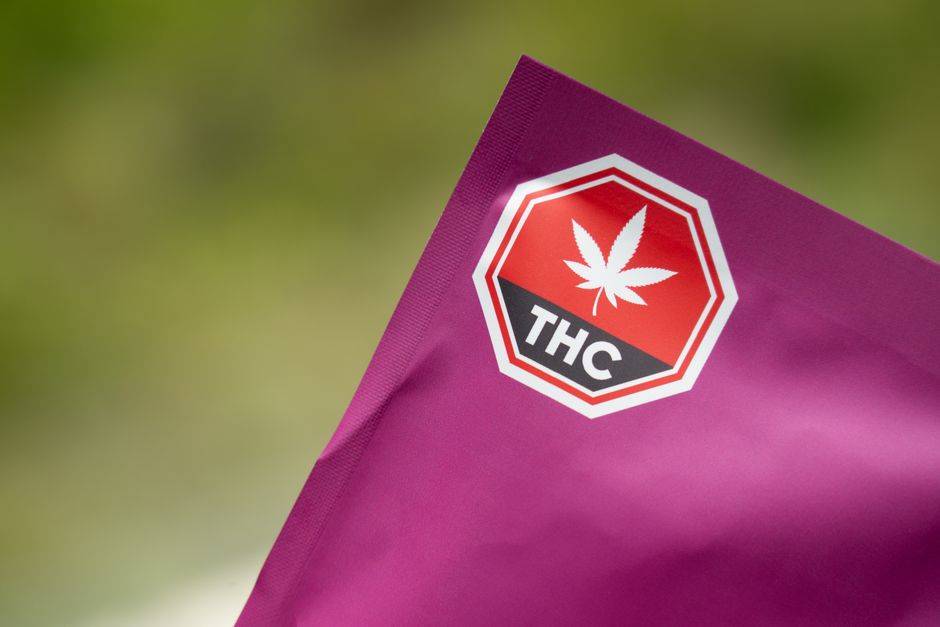 Espagne : le cannabis marocain au coeur de l’alerte du parquet Close-up of cannabis packaging with a THC warning label on a purple background, highlighting safety and regulatory compliance.