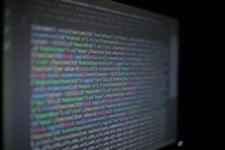 OpenAI et Claude : le test autorisé de Hacktron AI Close-up of colorful programming code on a blurred computer monitor.