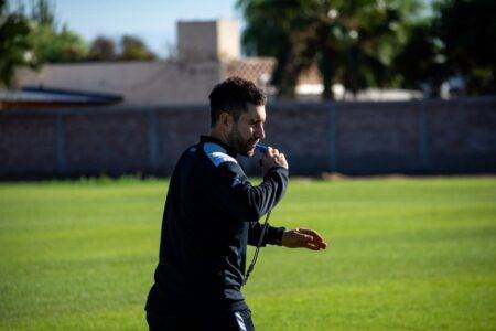 Ibrahim Hamdani face à une première liste ouverte Football coach blowing a whistle during practice on a sunny day outdoors.