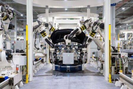 Tissemsilt : General Plastic Injection vise la chaîne automobile High-tech robots assembling a car in a modern factory setting, showcasing automation.