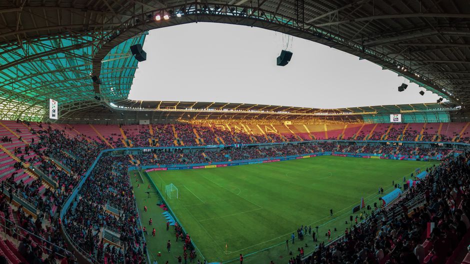 Championnat algérien : reprise du 22 septembre au 18 octobre Panoramic view of a bustling soccer stadium filled with enthusiastic fans during a vibrant match.