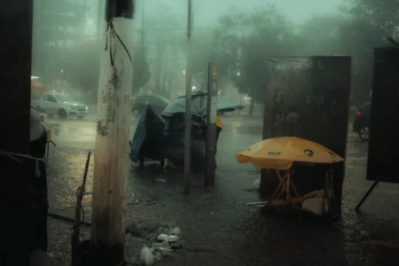 Pluies orageuses en Algérie : les wilayas exposées le 20 septembre 2026 Rainy urban scene with traffic and umbrellas during a thunderstorm at night.