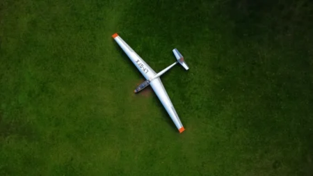 Europe : Paris, Varsovie et Berne face aux menaces hybrides Top-down view of a glider aircraft on a lush green field in Biržai, Lithuania.