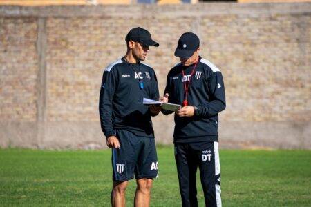 Aït Kaci : Hamdani n’écarte ni Belaïli ni Bounedjah Two soccer coaches reviewing strategies on the field during the day.