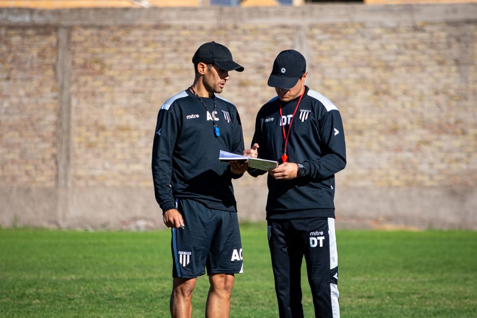 Aït Kaci : Hamdani n’écarte ni Belaïli ni Bounedjah Two soccer coaches reviewing strategies on the field during the day.
