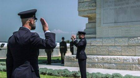 Sid Ahmed Agoumi, du théâtre à la mémoire algérienne Uniformed guards salute during a military ceremony at a monument.